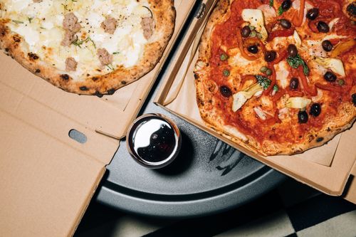 Free Top view of delicious pizzas in boxes with a refreshing drink, perfect for a cozy meal. Stock Photo