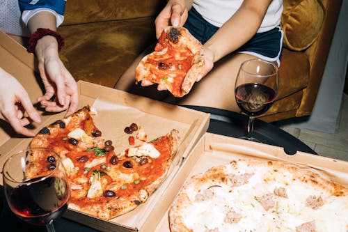 Two Person Getting a Slice of Pizza