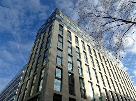 从低角度仰望现代摩天大楼，玻璃窗映衬着蓝天