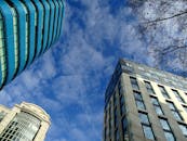 在阳光明媚的日子里，从低角度观看各种带有玻璃外墙的摩天大楼