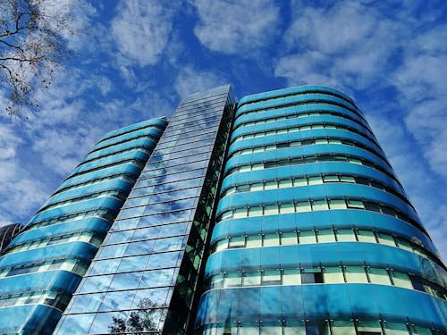 無料 青みがかったガラスの建物のローアングル写真 写真素材