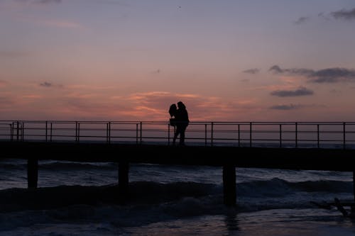 Silhouette of couple against sundown · Free Stock Photo