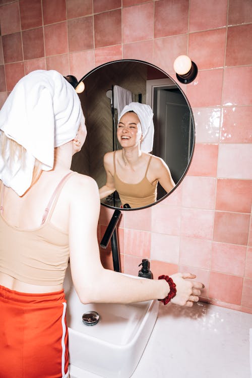 Young Woman Smiling While Looking at the Mirror