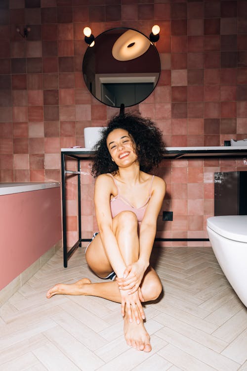 Free Girl Smiling While Sitting Inside the Bathroom Stock Photo