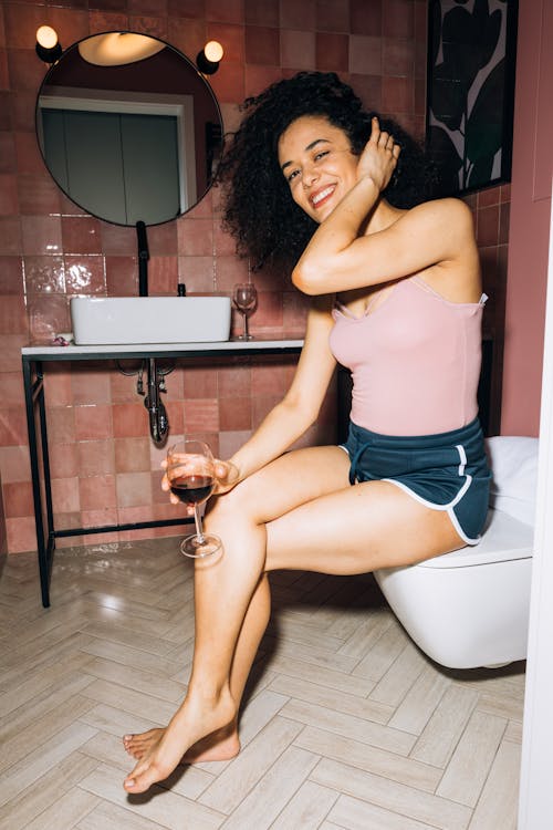 Free Girl Sitting While Holding a Wine Glass With Red Wine Stock Photo