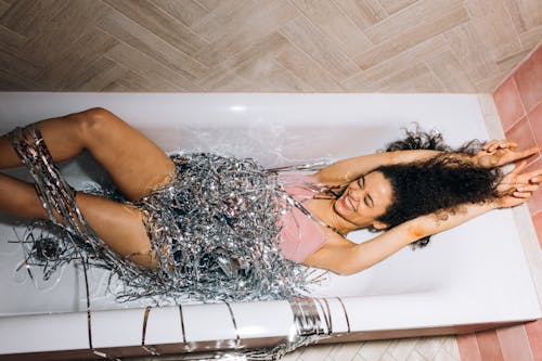 Free Girl Smiling While Lying Down in a Bathtub Stock Photo