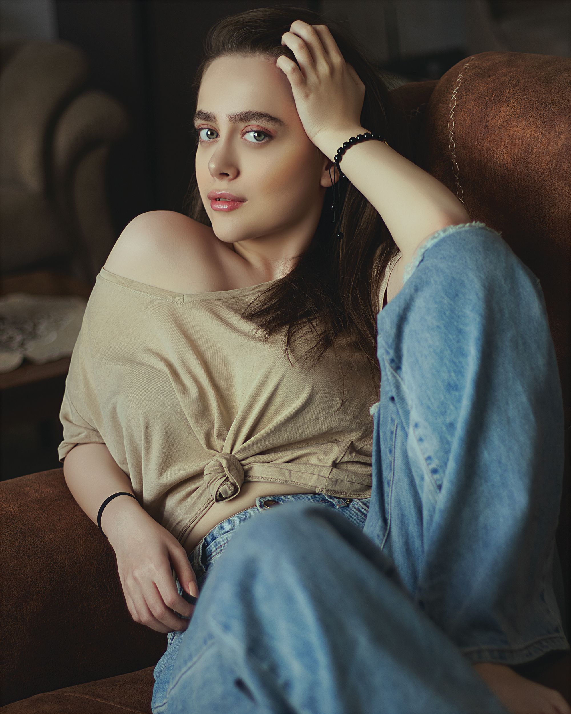 Woman in Beige Shirt Sitting on Brown Sofa · Free Stock Photo