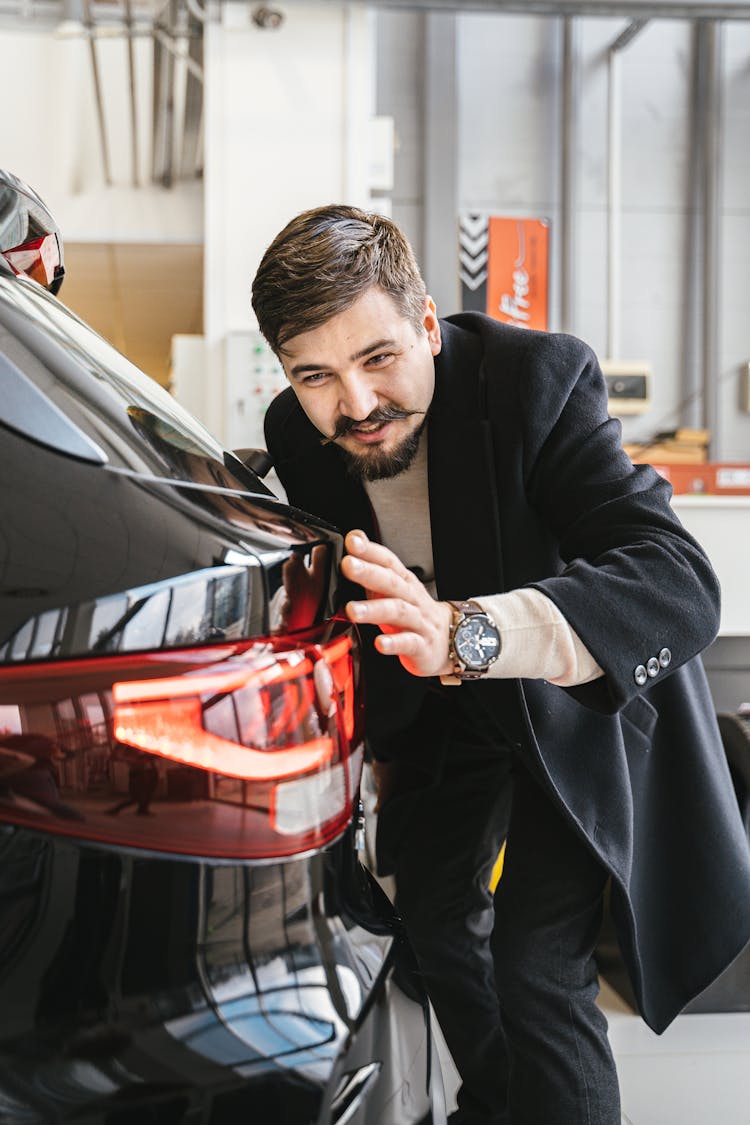 Man In Black Business Suit Touching Black Car