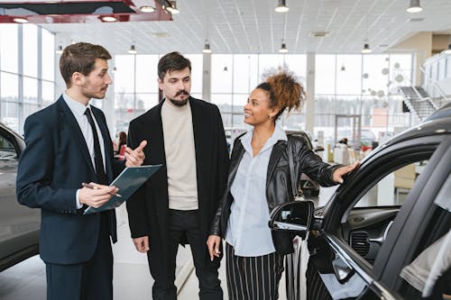 Free Man in Blue Business Suit Talking to Woman Touching the Car Stock Photo