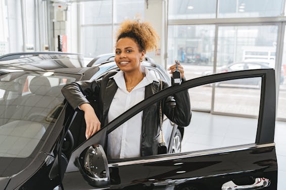 Woman in Black Blazer Standing Beside Black Car