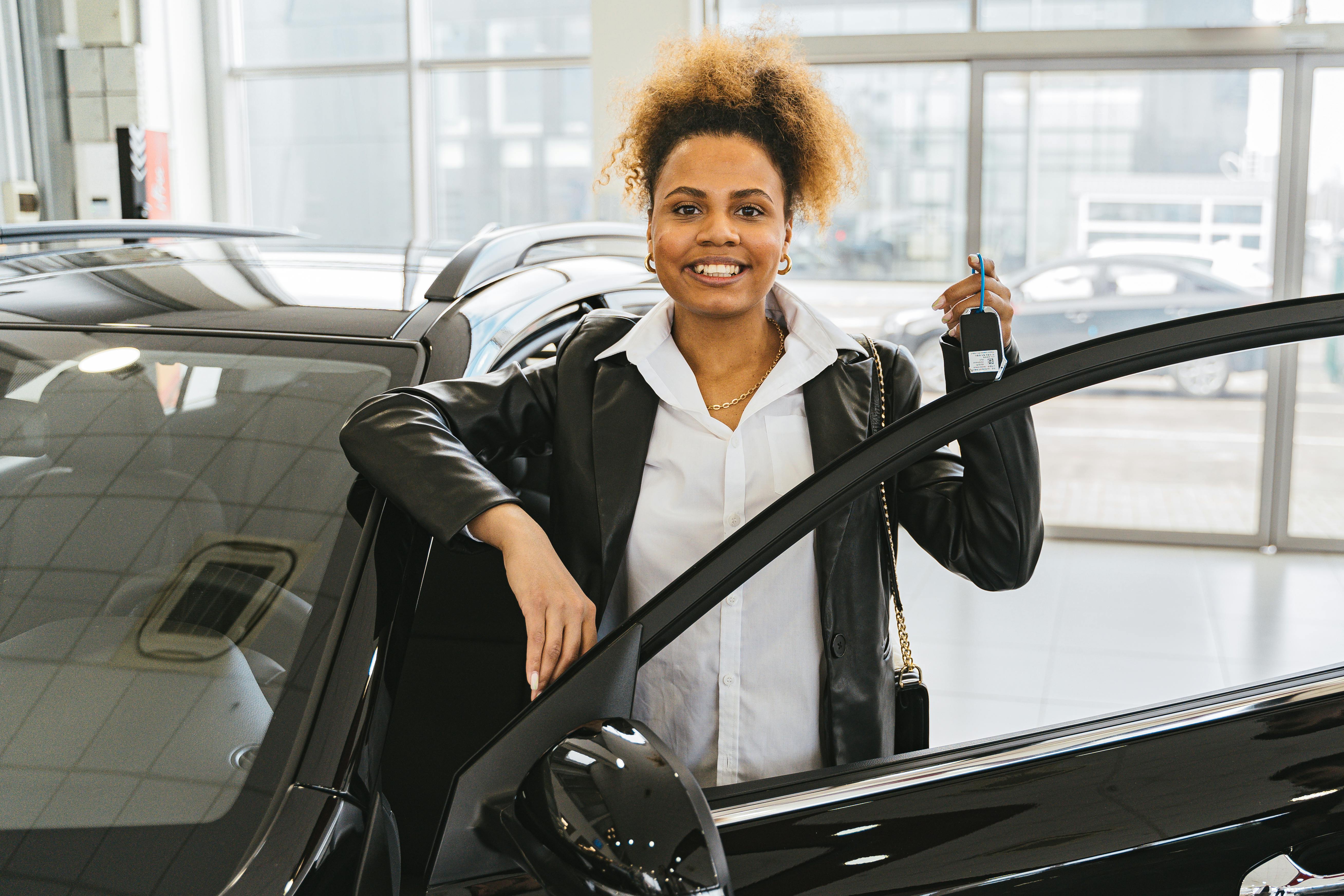 Woman in Black Blazer Holding Car Keys Smiling by Antoni Shkraba