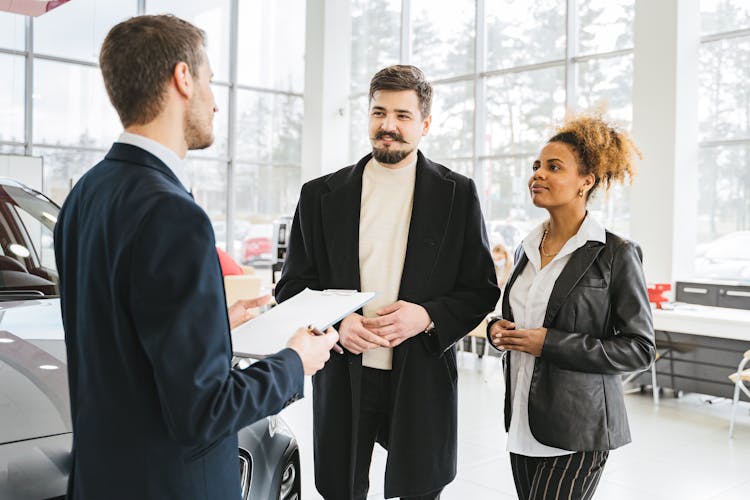 A Couple Talking To A Car Dealer 