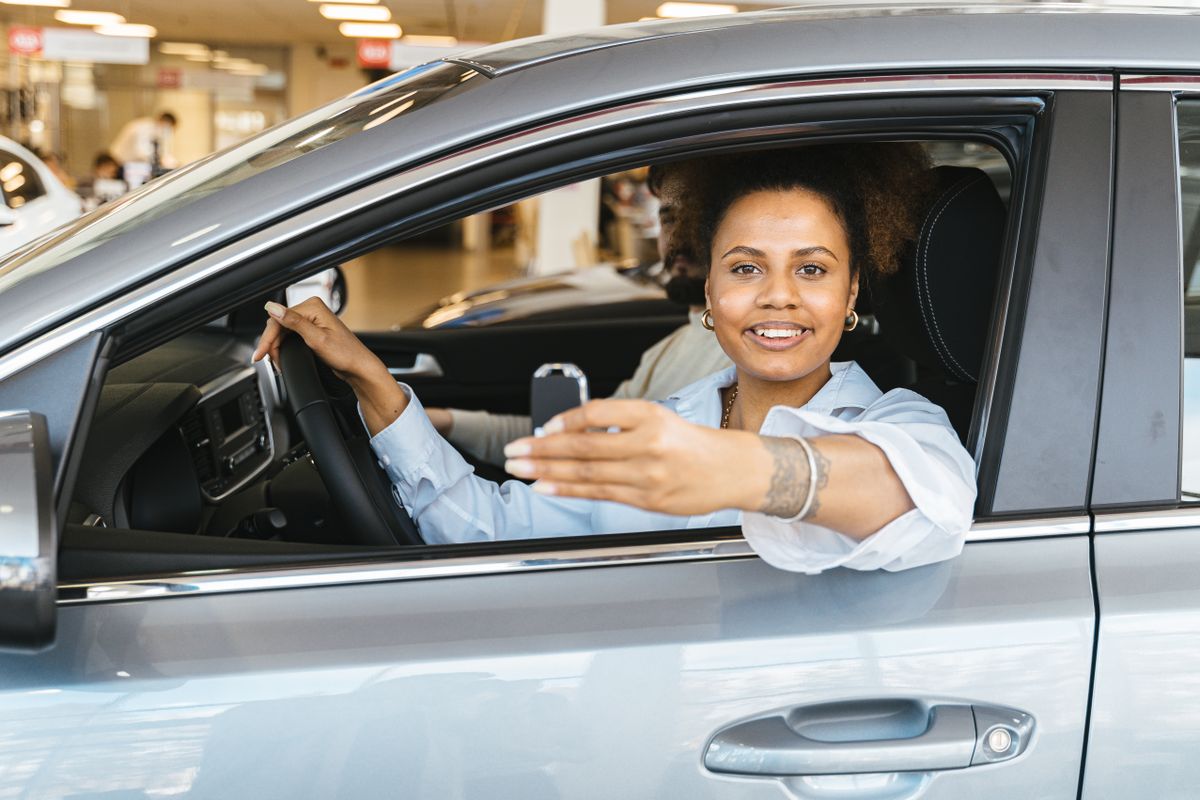 A smiling woman seated in her car, happy with the Vion experience