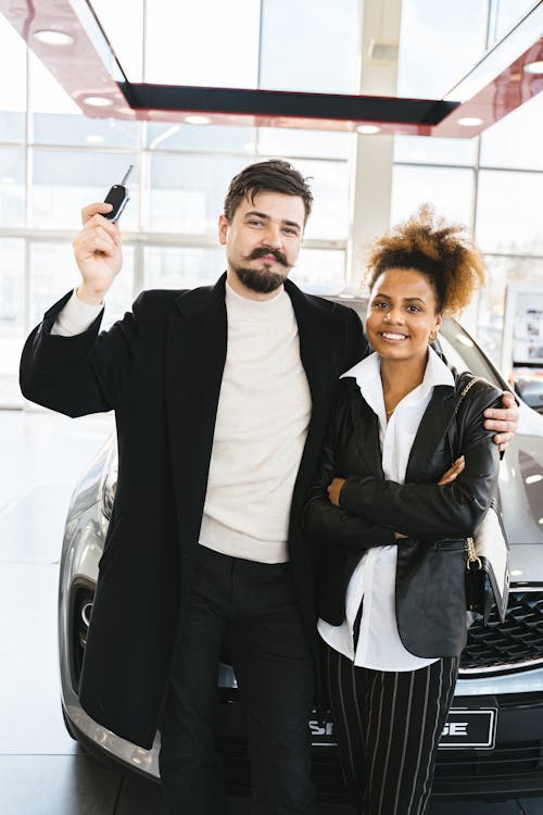 Free A Couple Standing in Front of a Brand New Car Stock Photo