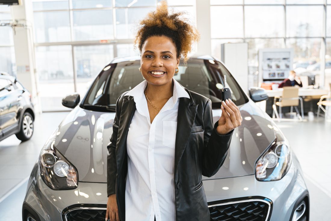 Fotografía representativa de una mujer adulta celebrando la compra de un carro
