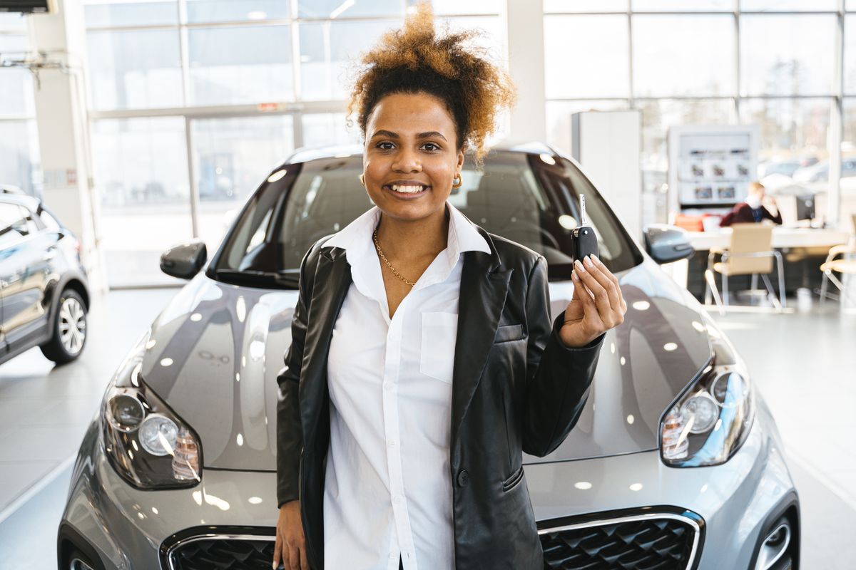 Woman holding car keys after buying a vehicle