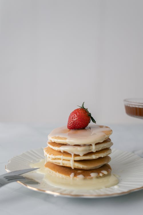 A Stack of Pancakes with a Strawberry on Top