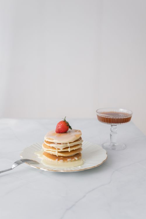 Free Elegant stack of pancakes topped with a fresh strawberry and drizzled in syrup. Stock Photo