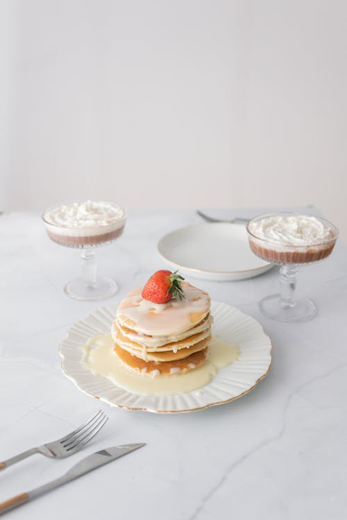 Free A Plate of Pancakes with Condensed Milk and a Strawberry Stock Photo