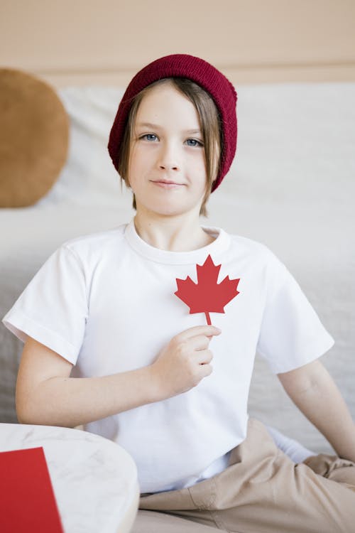A Kid Holding a Cutout of a Maple Leaf 