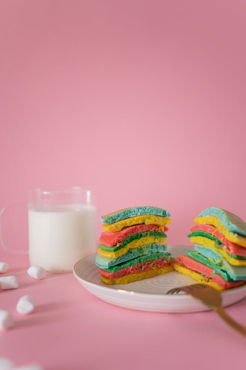 Free Yummy multicolored pancakes with cup of milk in pink studio Stock Photo