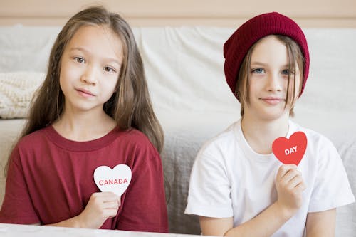 A Boy and A Girl Holding Hear Shaped Paper Cut-outs