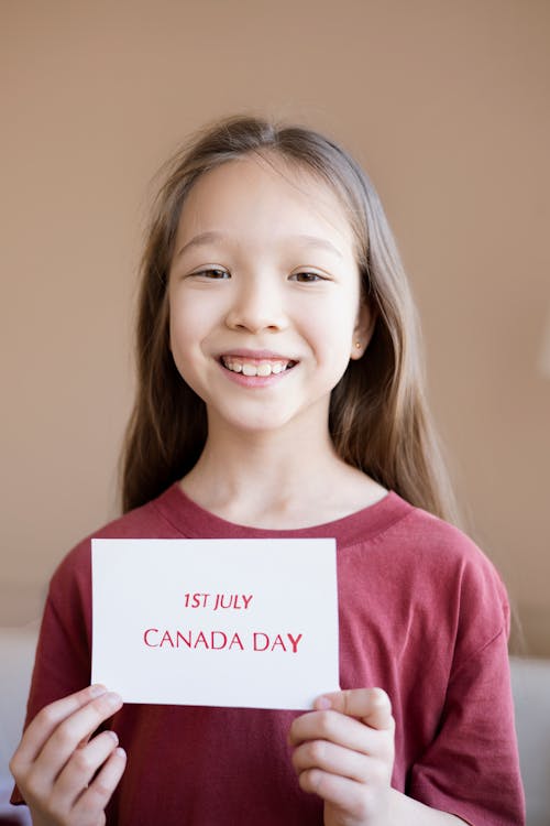 A Girl Holding a White Paper with Red Print