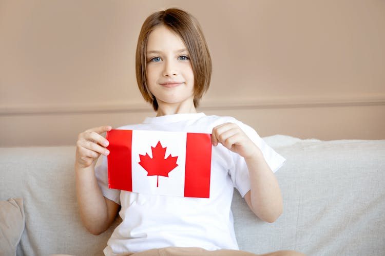 A Boy Proudly Holding A Flag