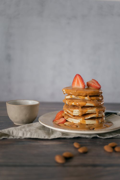 Free Delicious pancakes with topping near cup Stock Photo