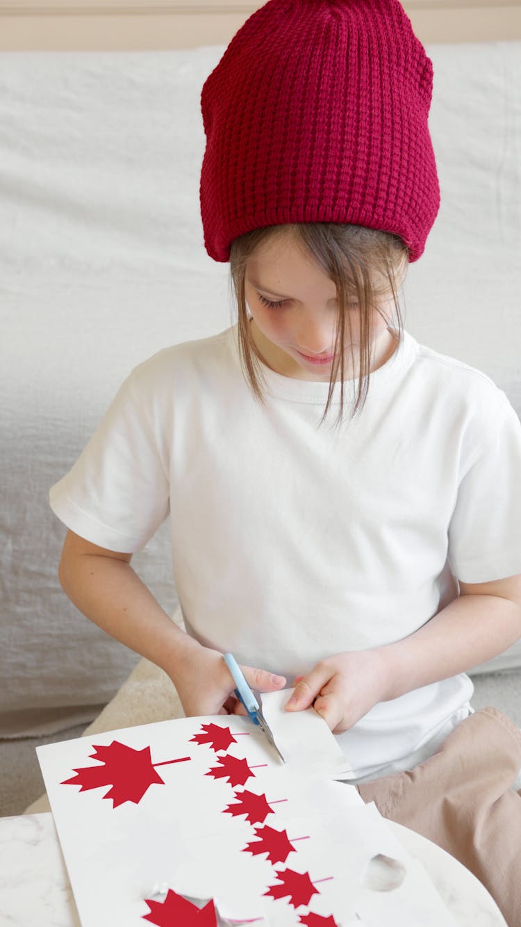 A Girl In White Shirt Cutting White Paper