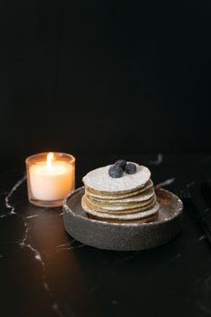 Pancakes with blueberries near candle