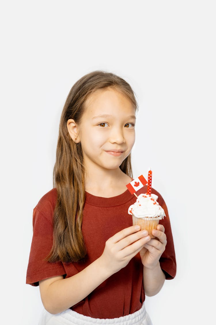 A Girl In Red Shirt Holding Cupcake