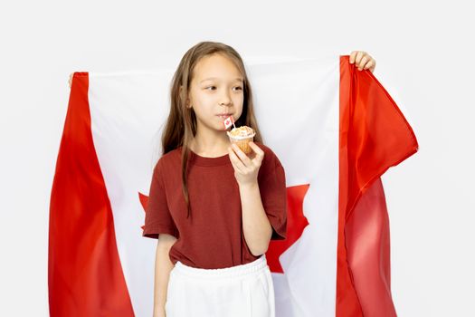 Adorable girl holding a cupcake and Canadian flag, celebrating national pride and delicious treats.