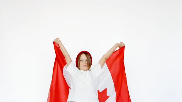 A child joyfully holding a Canadian flag, celebrating patriotism and freedom.