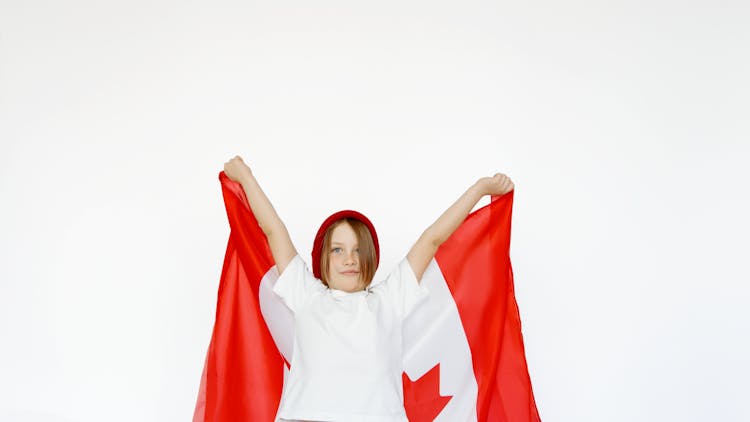 A Child Holding A Canada Flag