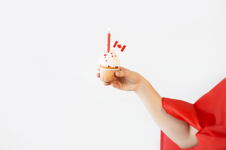 Hand Holding A White Cupcake With Canada Flag