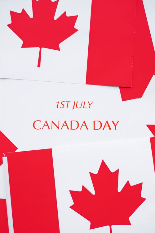 Free Red and white Canadian flags with 'Canada Day 1st July' text, ideal for holiday themes. Stock Photo