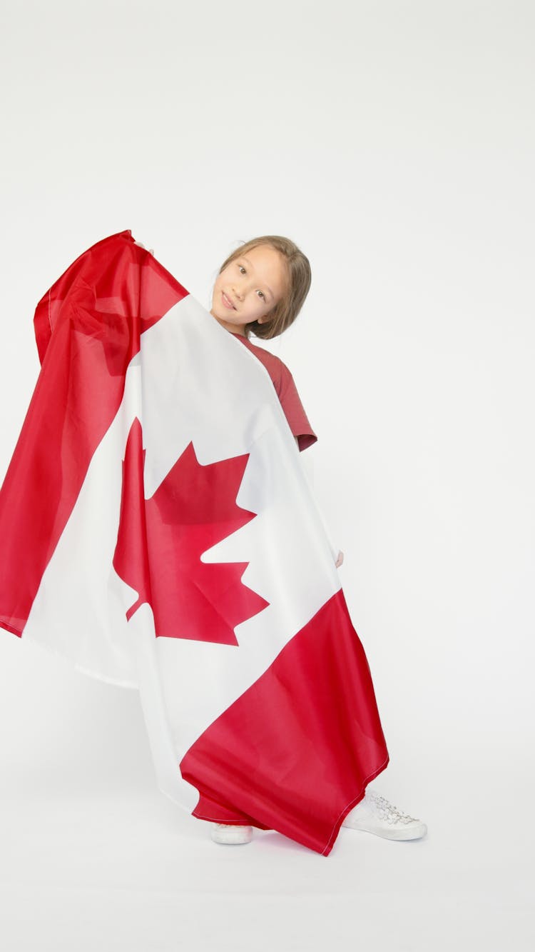 A Girl Holding A Big Canada Flag