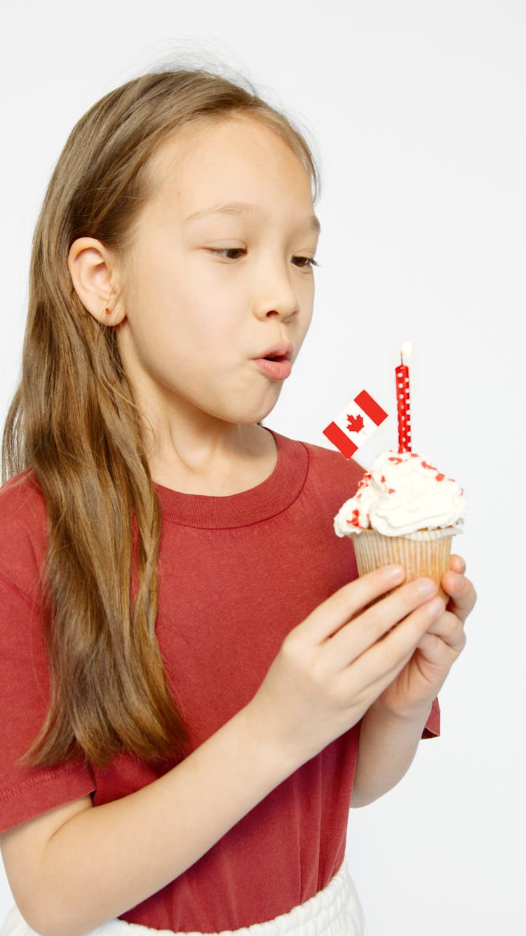 Girl Holding A White Cupcake With Canada Flag