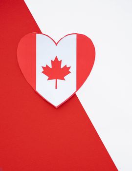 A heart-shaped Canadian flag symbolizing Canada Day on a vibrant red and white backdrop.