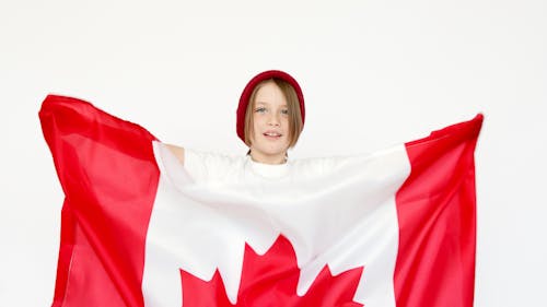 Free Boy in Red Bonnet Holding Canadian Flag Stock Photo