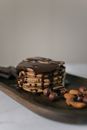 Delicious pancakes decorated with chocolate and nuts on timber board