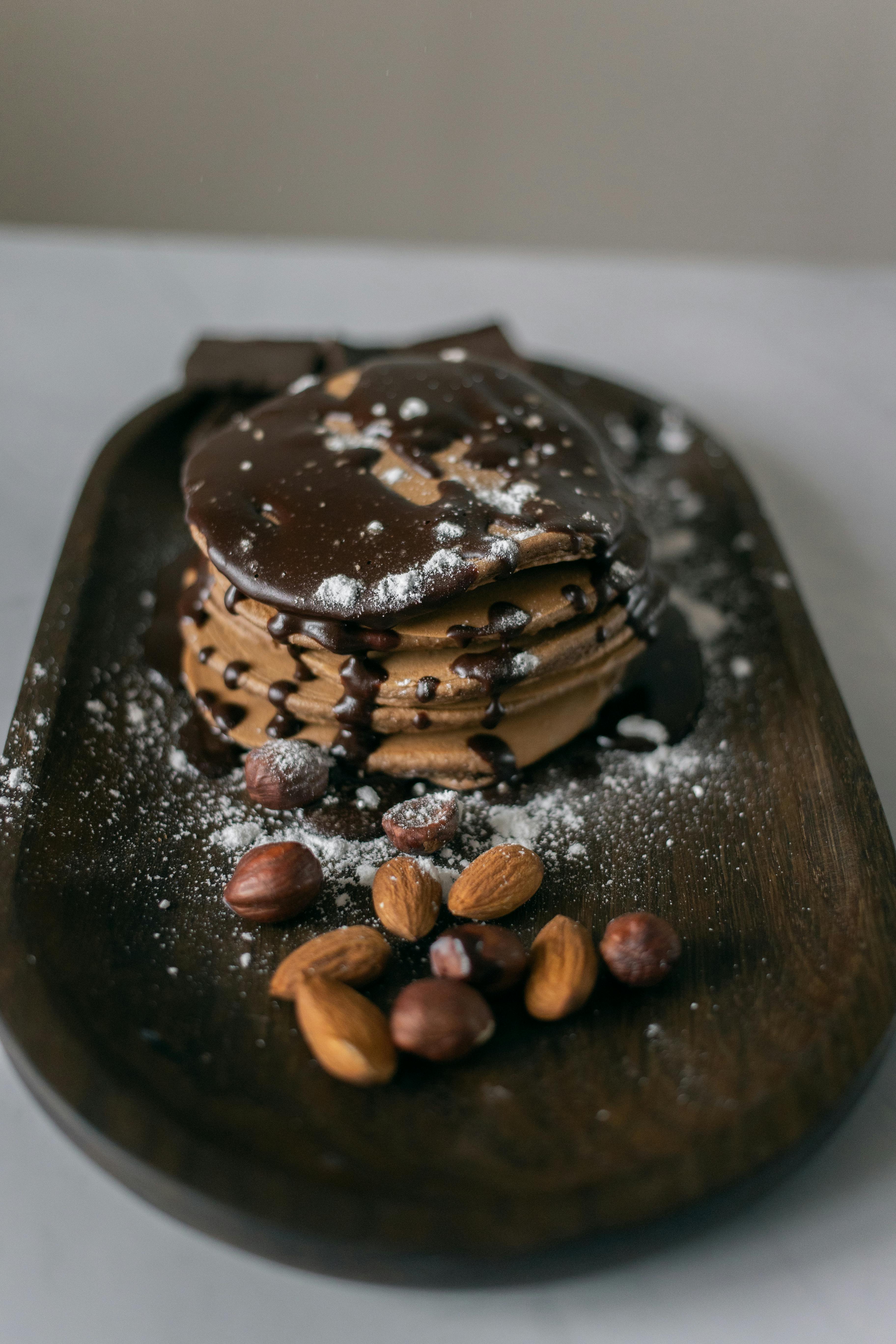 chocolate pancake on dark tray with hazelnuts and almonds