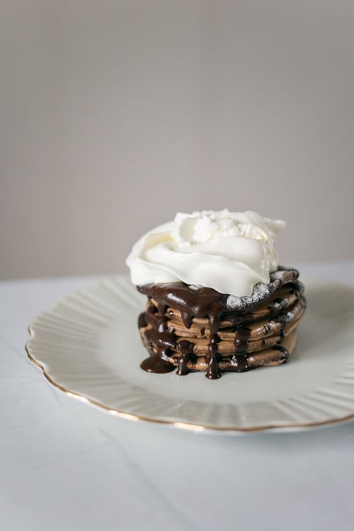 Free Appetizing sweet chocolate pancake with cream topping placed on plate on white table Stock Photo