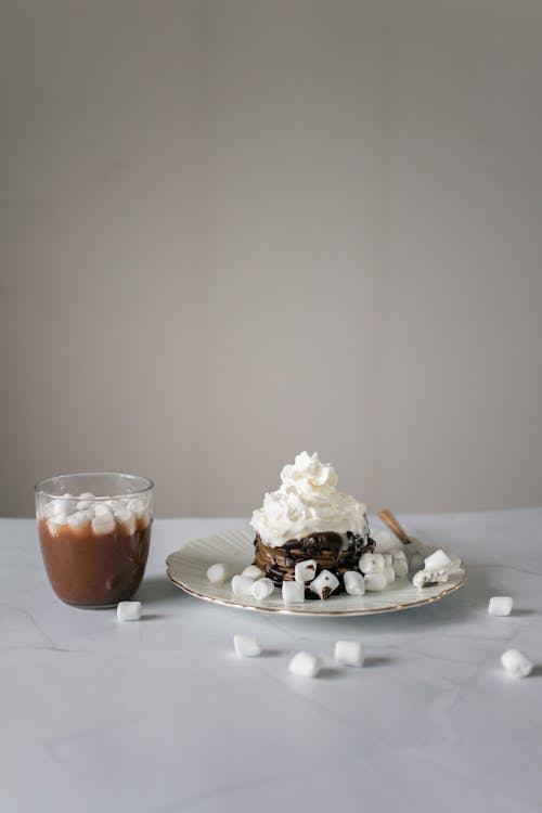 Chocolate pancake with marshmallows near glass of chocolate