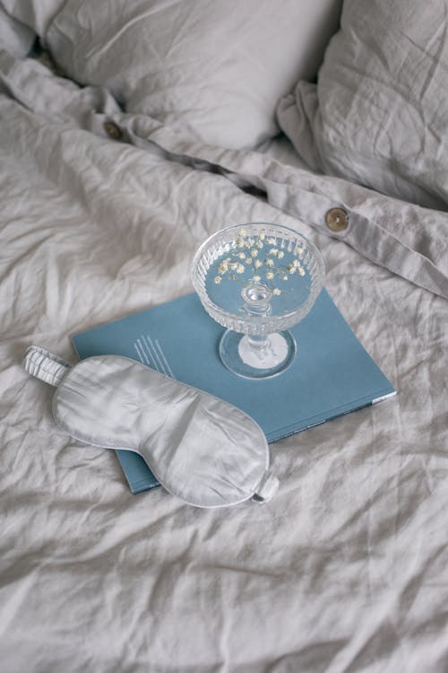 Free Bright Gray Linen with a Sleep Mask and Book Stock Photo