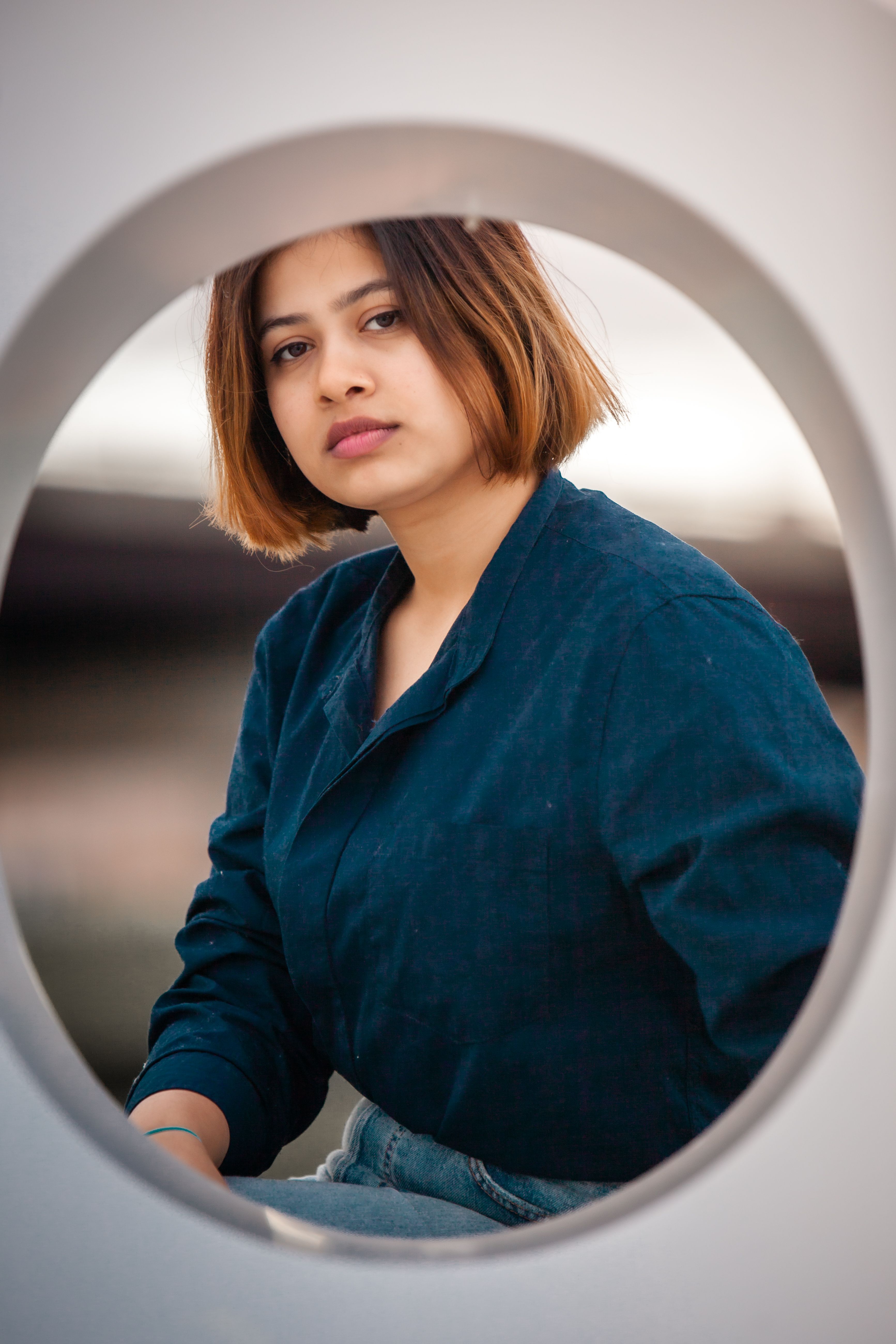 Portrait of a Woman in Blue Shirt through a Round Window · Free Stock Photo