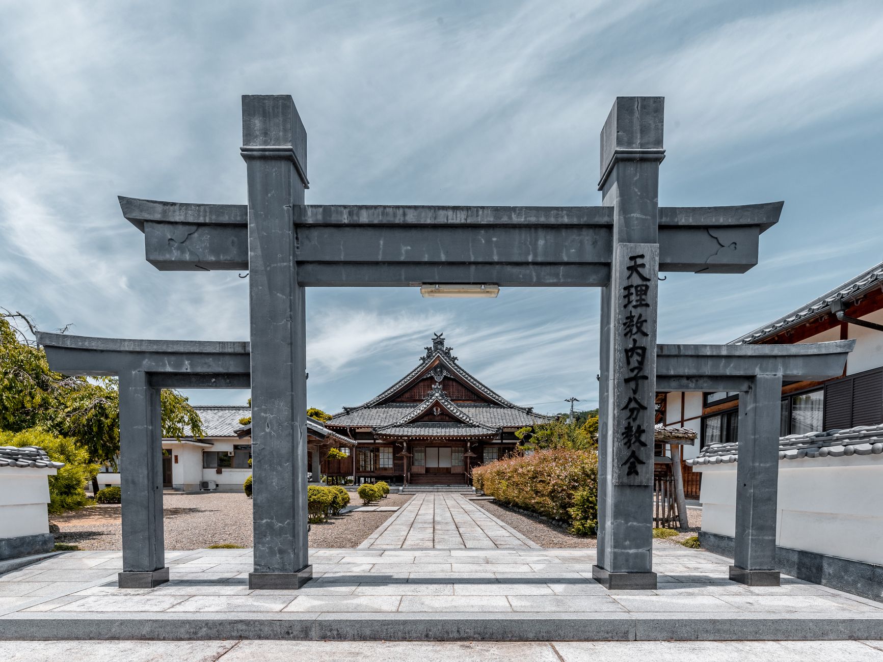 Peaceful view of a traditional Japanese temple entrance with a Torii gate.