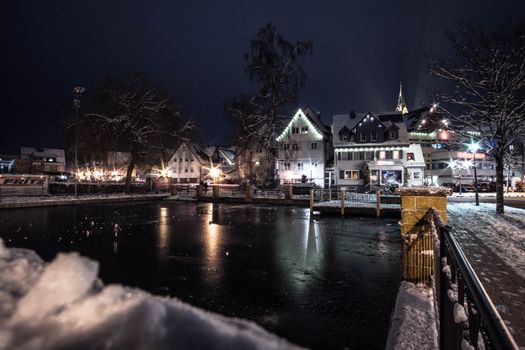 德国韦尔茨海姆迷人的夜间城市景观，在白雪覆盖的环境中映衬着明亮的建筑