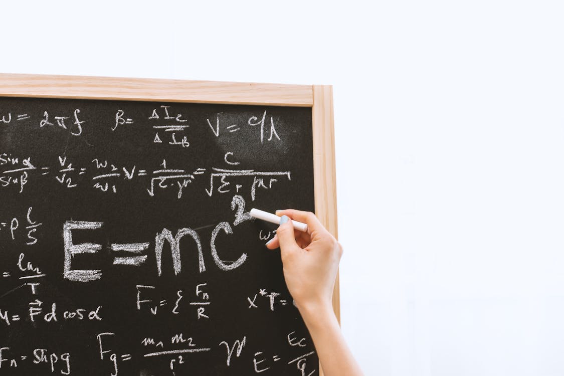 Free Person Holding a Chalk in Front of the Chalk Board Stock Photo